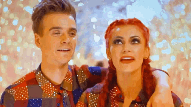 a man and a woman with red hair are standing next to each other