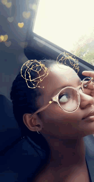 a woman wearing glasses looks out a car window