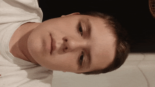 a close up of a young boy 's face with a black background