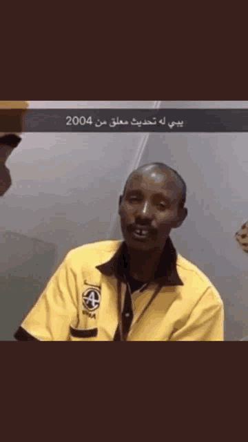 a man in a yellow shirt with the year 2004 on the bottom right