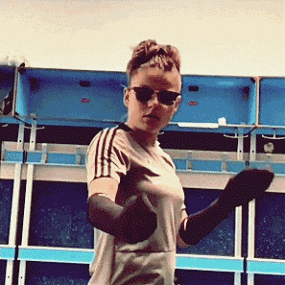 a woman wearing sunglasses and gloves is dancing