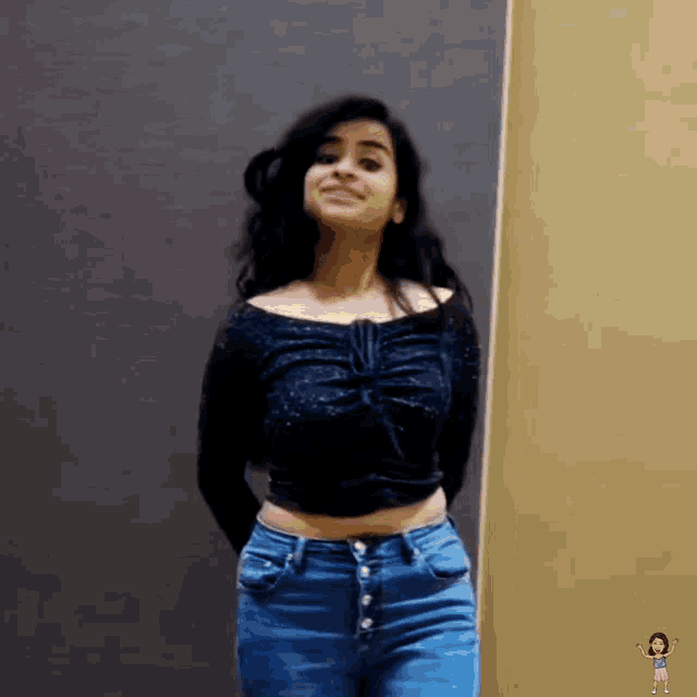 a woman in a black off the shoulder top and jeans