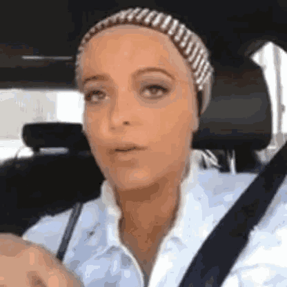 a woman wearing a headband is sitting in a car .