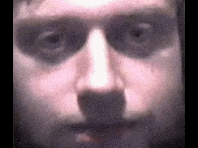 a close up of a man 's face with black eyes and a white nose