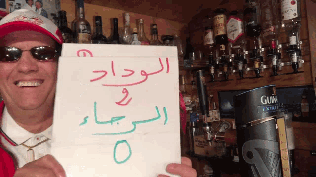 a man holding up a sign that says guinness