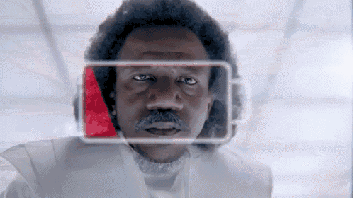 a man in a white suit is looking at a screen with a red arrow on it .