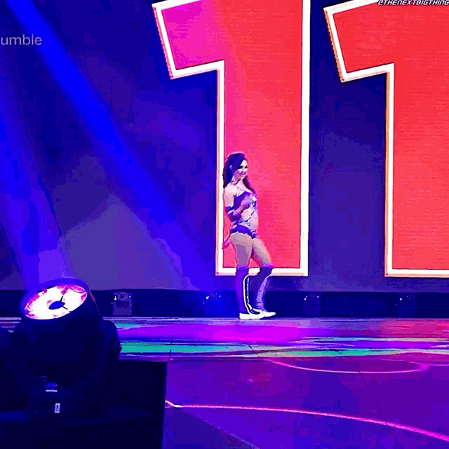 a woman stands on a stage in front of a number 11