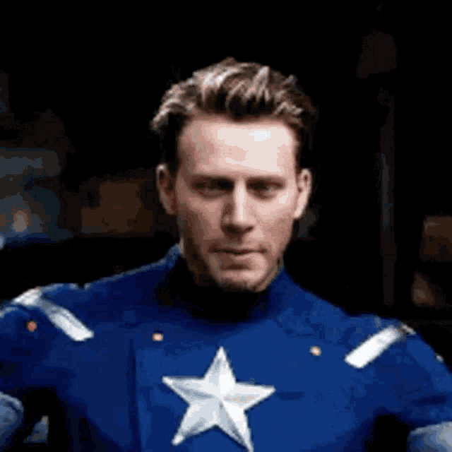 a close up of a man in a captain america costume holding a glove .