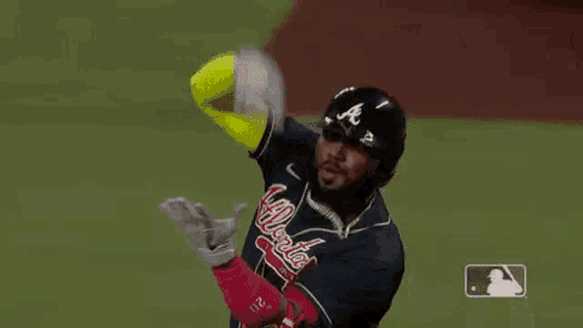 a baseball player is catching a ball with his glove .