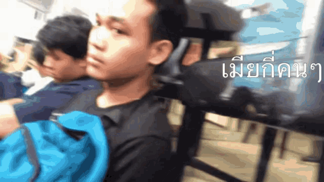 a blurry picture of a man with a blue backpack and a foreign language on the bottom right