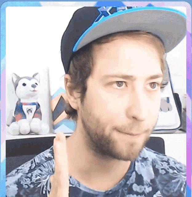 a man with a beard wearing a hat that says ' x ' on it