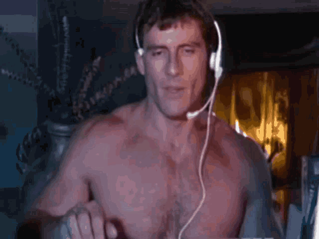 a shirtless man is wearing headphones and a microphone .