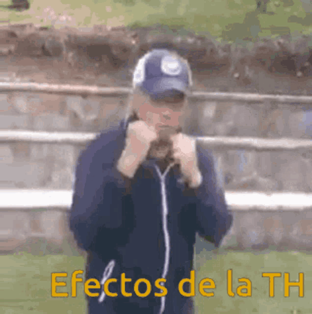 a man in a baseball cap is standing in front of a wall with the words efectos de la th written on the bottom