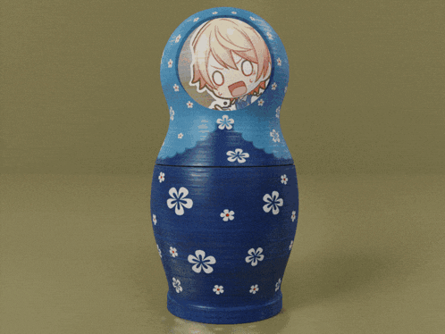 a blue green and orange nesting doll with a picture of a girl on it