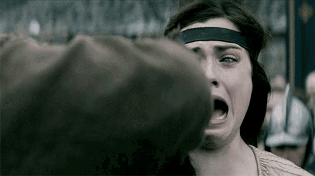 a woman with a headband on her head is making a funny face