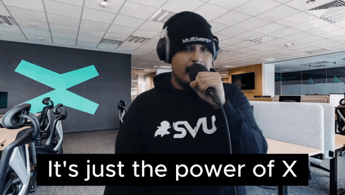 a man singing into a microphone wearing a svu hoodie