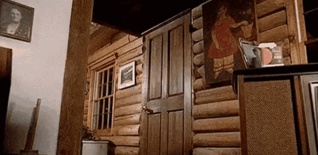a log cabin with a painting of a girl on the wall .