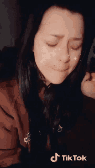 a woman 's face is shown with a tiktok logo above her