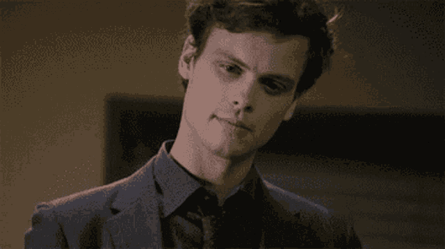 a man in a suit and tie is making a serious face