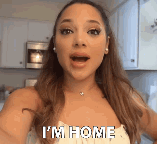 a woman says i 'm home in front of a microwave