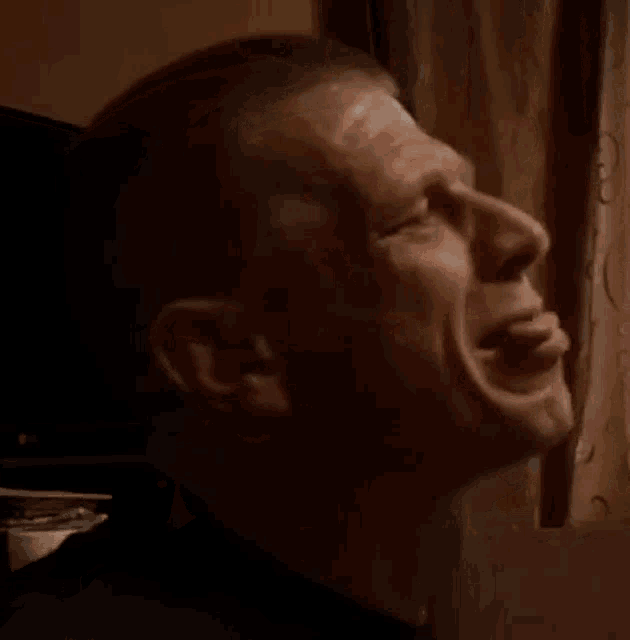 a close up of a man 's face with a window in the background