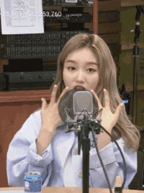 a woman is sitting in front of a microphone and making a funny face .