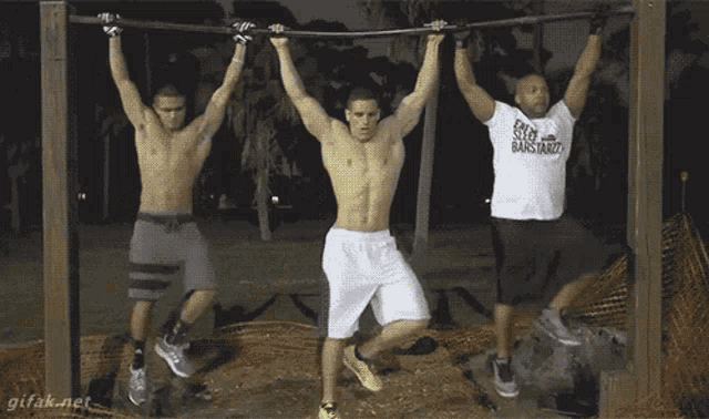 three men are hanging upside down on a bar one of them is wearing a shirt that says keep it bastardly
