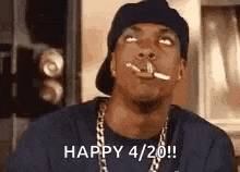 a man in a hat and chains is smoking a cigarette and says `` happy 4/20 '' .