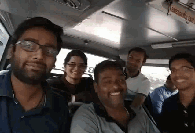 a group of people on a bus with the word emergency on the ceiling above them