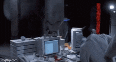 a man in a lab coat is sitting at a desk in front of a computer screen .