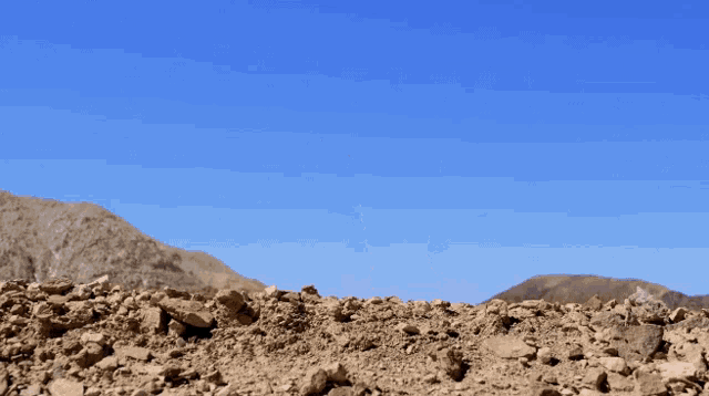 a woman with a bow and arrow is kneeling down in the dirt