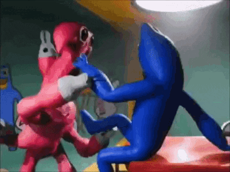 two cartoon characters , one pink and one blue , are fighting each other in a room .