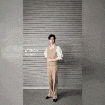 a man in a suit is standing in front of a garage door