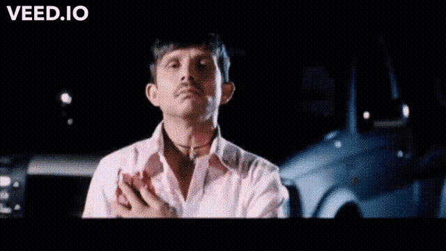 a man in a white shirt is holding his hand to his chest and says magar kyu