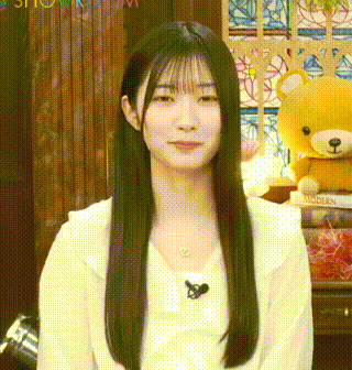 a young woman with long hair is sitting in front of a teddy bear .