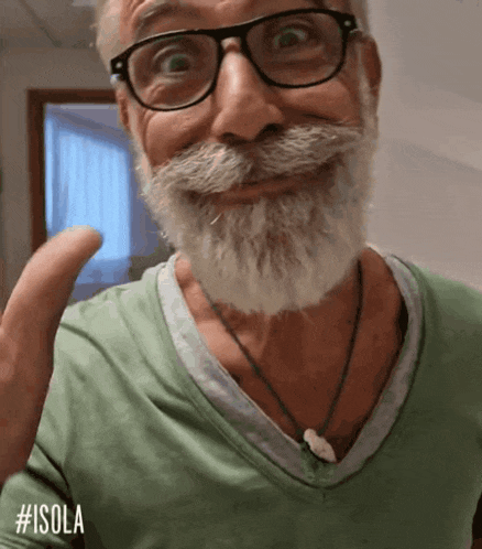a man with glasses and a beard is wearing a green shirt that says #isola on it