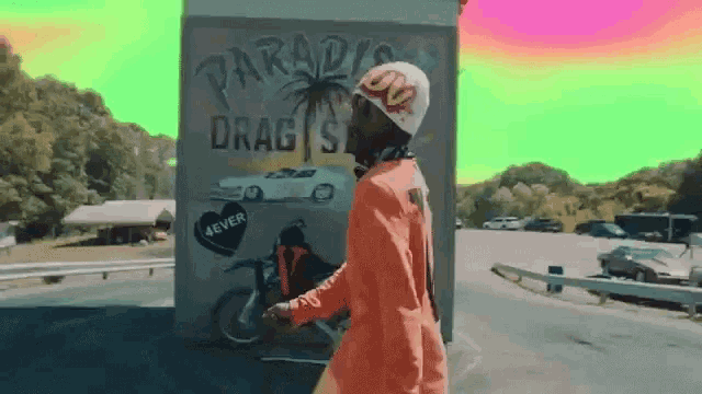 a man standing in front of a sign that says paradise drag shop