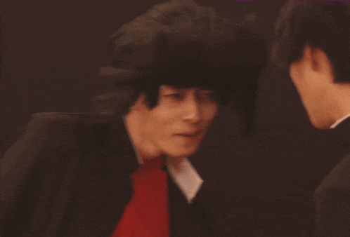 two men are looking at each other and one has a wig on his head