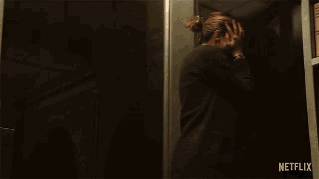 a woman in an elevator with a netflix logo on the bottom