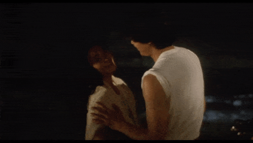 a man and woman are dancing with their arms in the air