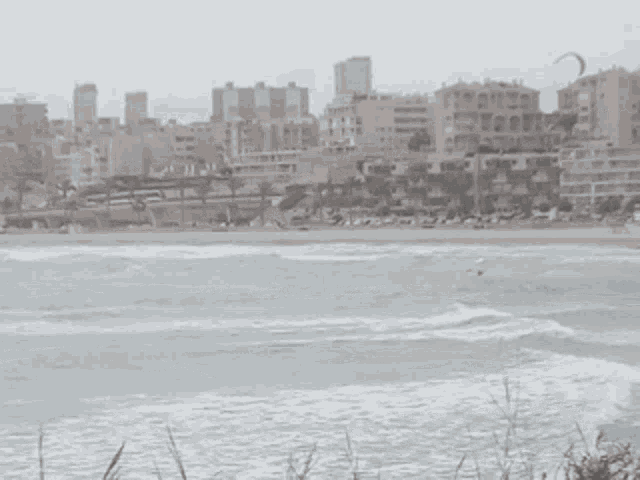 a large body of water surrounded by buildings with a city in the background