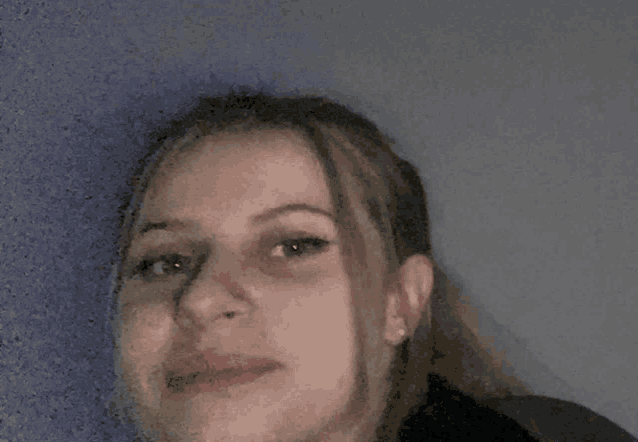 a close up of a woman 's face with a ponytail