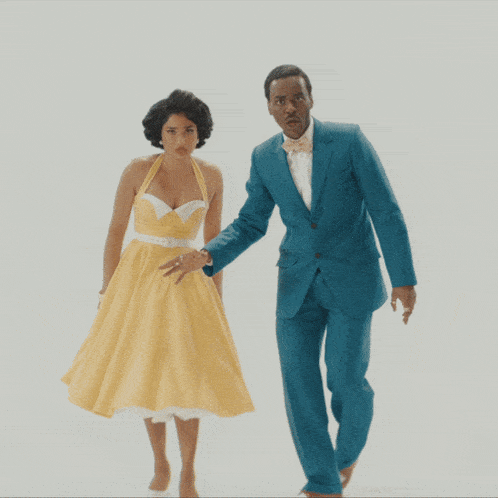 a man in a blue suit and a woman in a yellow dress