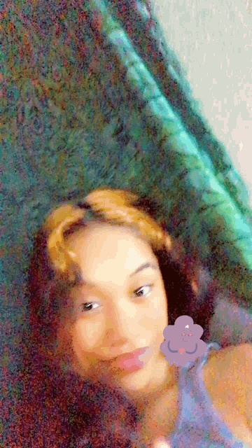 a blurry picture of a girl with a purple flower on her neck