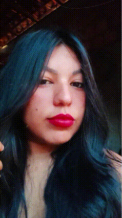 a woman with blue hair and red lips is wearing a wig .
