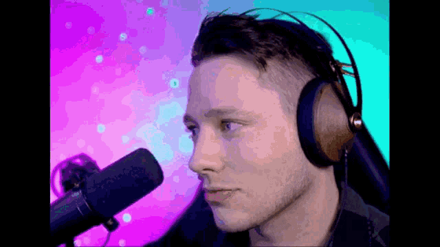 a man wearing headphones and a microphone looks at the camera .