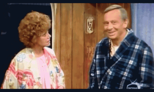 a man and a woman are standing next to each other in front of a door that has the letter g on it