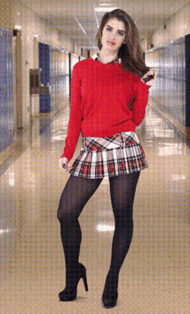 a woman wearing a red sweater and plaid skirt is standing in a hallway