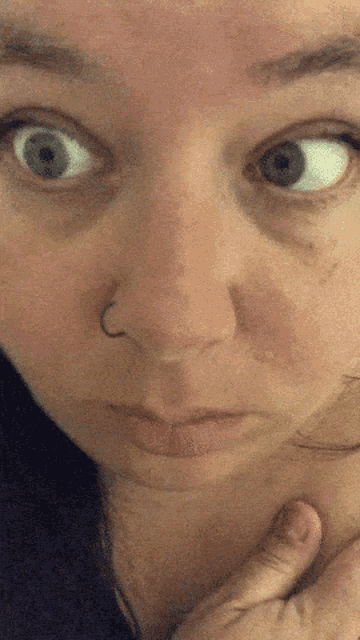 a close up of a woman 's face with a nose ring on it