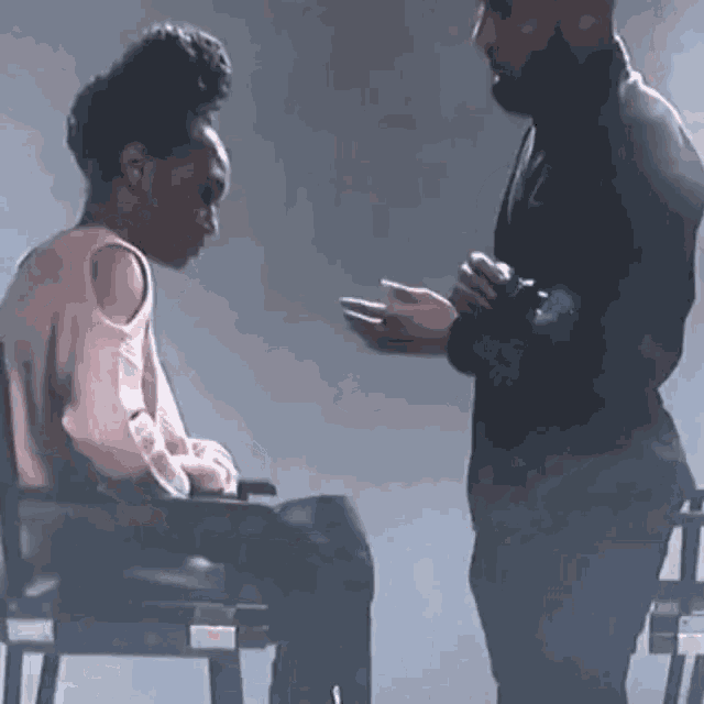 a man is talking to a woman in a wheelchair